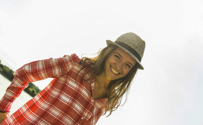 Portrait of happy young woman wearing hat outdoors - UUF005027