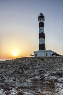 Spain, Balearic Islands, Menorca, view of Artrutx lighthouse at sunset - MGOF000335