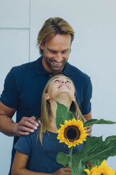 Lächelnder Vater und Tochter mit Sonnenblume - CHAF000847