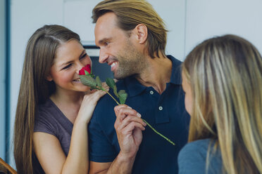 Smiling couple with red rose and daughter - CHAF000850