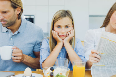 Frustriertes Mädchen mit abgelenkten Eltern am Frühstückstisch - CHAF000874