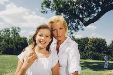 Portrait of mother and daughter together in a park - CHAF001554