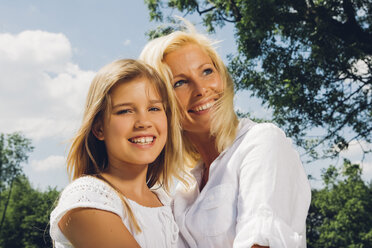 Porträt eines glücklichen Mädchens im Teenageralter mit ihrer Mutter in einem Park - CHAF000899