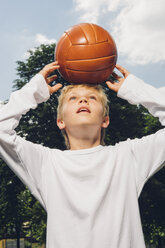 Junge balanciert einen Volleyball auf seinem Kopf - CHAF000905