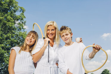 Porträt einer glücklichen Frau und ihrer Kinder mit Tennisschlägern - CHAF000913