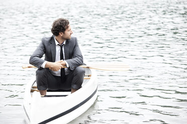 Germany, Rur Reservoir, businessman relaxing in canoe - MFRF000253