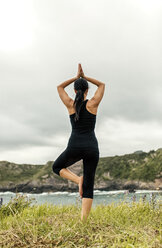 Spain, Asturias, Gijon, woman doing yoga outdoors - MGOF000353