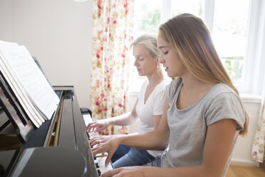 Mutter und Tochter spielen zusammen Klavier - SGF001786