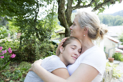 Mutter und Tochter umarmen sich, lizenzfreies Stockfoto