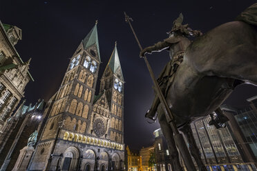 Germany, Bremen, Equestrian statue and Bremen Cathedral at night - NKF000334