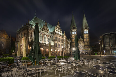 Germany, Bremen, view to townhall and Bremen Cathedral with sidewalk cafe in the foreground at night - NKF000336