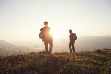 Österreich, Tirol, Paar beim Wandern am Unterberghorn bei Sonnenuntergang - RBF002934