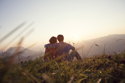 Austria, Tyrol, Unterberghorn, two hikers resting in alpine landscape at sunset - RBF002941