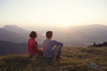 Austria, Tyrol, Unterberghorn, two hikers resting in alpine landscape at sunset - RBF002942