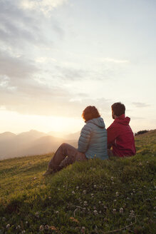 Österreich, Tirol, Unterberghorn, zwei Wanderer rasten in alpiner Landschaft bei Sonnenaufgang - RBF002960