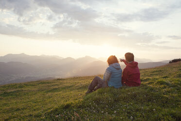 Austria, Tyrol, Unterberghorn, two hikers resting in alpine landscape at sunrise - RBF002962