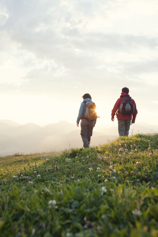 Österreich, Tirol, Paar wandert am Unterberghorn bei Sonnenaufgang, lizenzfreies Stockfoto