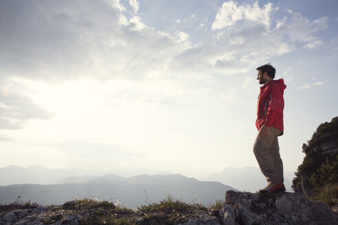 Österreich, Tirol, Unterberghorn, Wanderer steht in alpiner Landschaft und schaut auf die Aussicht - RBF002973