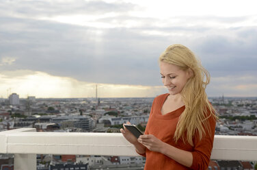 Germany, Berlin, young woman using smartphone - BFRF001399