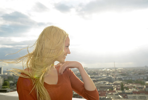 Deutschland, Berlin, junge Frau mit wehenden Haaren schaut auf Aussicht, lizenzfreies Stockfoto