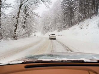 Austria, Kitzbuehel Region, cars on road in winter landscape - AMF004118