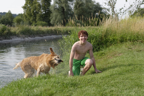 Lächelnder Teenager und ein Golden Retriever nach dem Baden, lizenzfreies Stockfoto