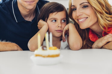 Familie mit Tochter feiert Geburtstag mit Kerzen auf Kuchen - CHAF000989
