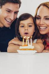 Family with daughter celebrating birthday with candles on cake - CHAF000990
