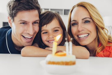 Family with daughter celebrating birthday with candles on cake - CHAF000993