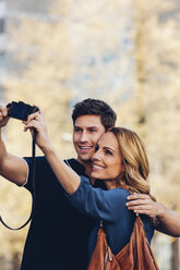 Smiling couple outdoors taking a selfie - CHAF000937