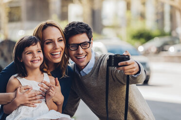 Mann im Freien, der mit einer Digitalkamera ein Selfie von seiner Familie macht - CHAF001040