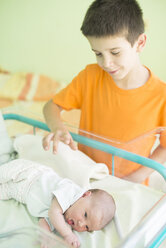 Junge beobachtet seine neugeborene Schwester in einem Krankenhaus - DEGF000475
