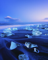 Iceland, view to glacial lake Jokulsarlon, glacier ice on beach at twilight - SMAF000355