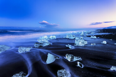 Iceland, view to glacial lake Jokulsarlon, glacier ice on beach at twilight - SMAF000356