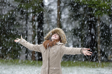 Mädchen genießt den Schneefall, Beginn des Winters - LBF001145