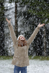 Girl enjoying snow fall, beginning of winter - LBF001143