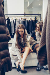 Zwei junge Frauen kaufen Schuhe in einer Boutique - CHAF001335