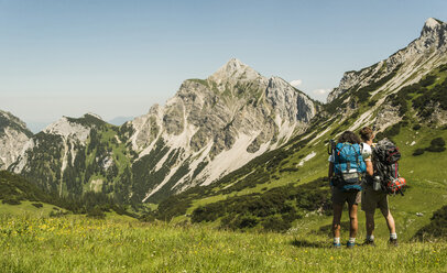 Österreich, Tirol, Tannheimer Tal, junges Paar auf Almwiese stehend - UUF005052