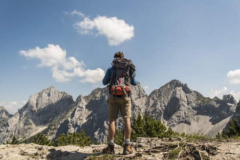 Österreich, Tirol, Tannheimer Tal, junger Mann steht auf einem Bergpfad und betrachtet die Aussicht - UUF005066