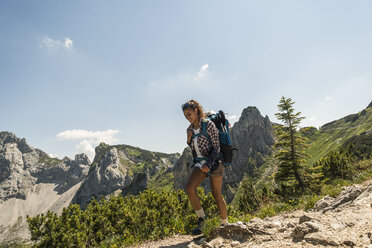 Austria, Tyrol, Tannheimer Tal, young woman hiking on mountain trail - UUF005070