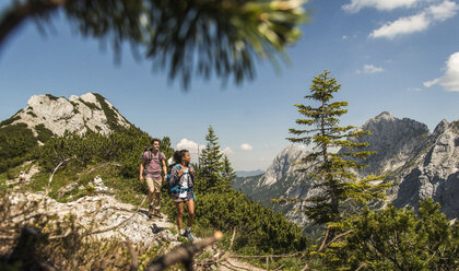 Austria, Tyrol, Tannheimer Tal, young couple hiking on mountain trail - UUF005071