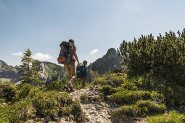 Austria, Tyrol, Tannheimer Tal, young couple hiking on mountain trail - UUF005074