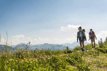 Austria, Tyrol, Tannheimer Tal, young couple hiking on mountain trail - UUF005076