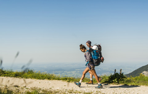 Österreich, Tirol, Tannheimer Tal, junges Paar wandert auf Bergpfad, lizenzfreies Stockfoto