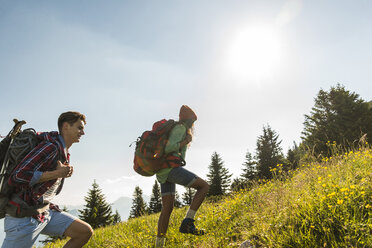 Austria, Tyrol, Tannheimer Tal, young couple hiking on alpine meadow - UUF005090