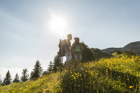 Österreich, Tirol, Tannheimer Tal, junges Paar auf Almwiese stehend, lizenzfreies Stockfoto