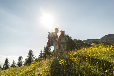 Österreich, Tirol, Tannheimer Tal, junges Paar auf Almwiese stehend - UUF005091