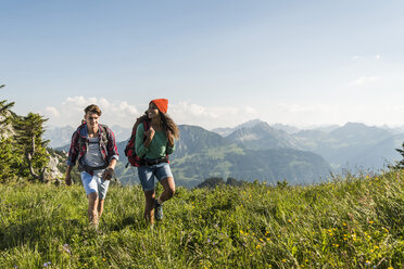 Austria, Tyrol, Tannheimer Tal, young couple hiking on alpine meadow - UUF005093