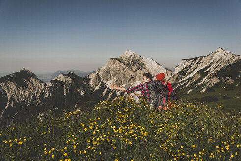 Österreich, Tirol, Tannheimer Tal, junges Paar rastet auf Almwiese - UUF005096