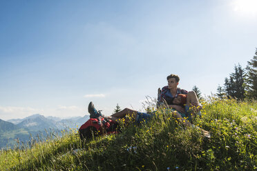 Österreich, Tirol, Tannheimer Tal, junges Paar rastet auf Almwiese - UUF005099